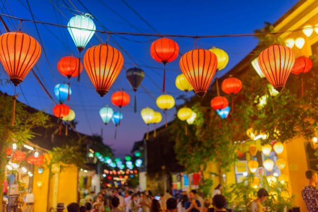A street in Hoi An with yellow walls and lanterns