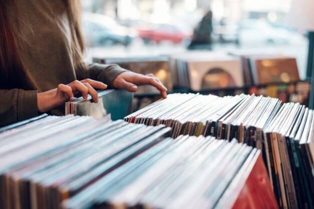 Person at record store rifling through vinyl