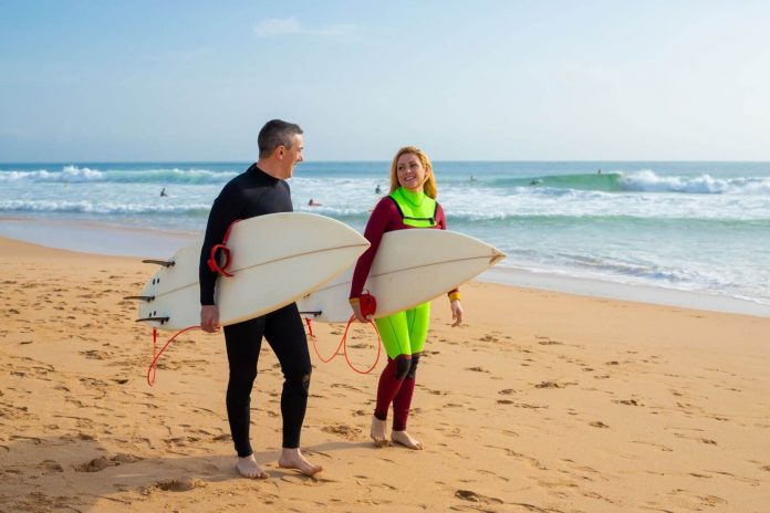 middle aged couple learn to surf