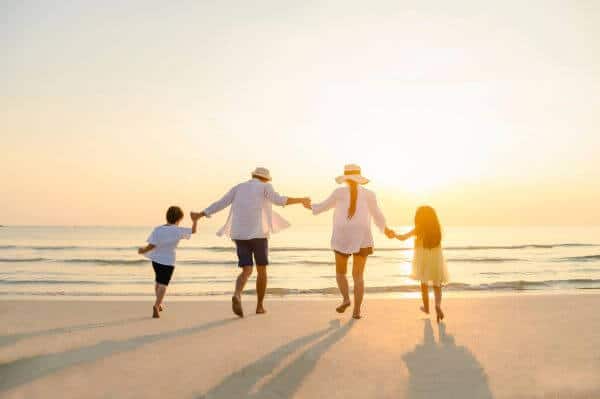 A family playing on a beach at sunset
