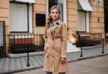 How to layer for a British autumn: five outfits from your own wardrobe Woman wearing a camel trench coat over a striped shirt and jeans