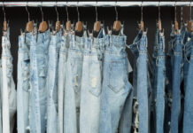 How to buy second-hand jeans that actually fit Blue jeans in different washes hanging from clip hangers on a clothes rail