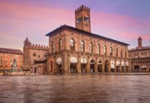 A food-focused weekend in Bologna: a two-night itinerary Historic buildings and the Neptune Fountain beside Piazza Maggiore in Bologna under a pink sky