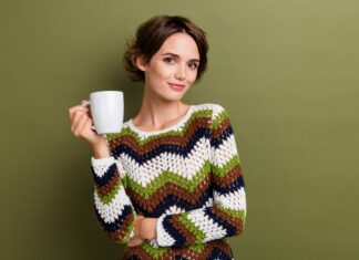 How to care for wool knitwear: washing, bobbles and storage Woman wearing a multicoloured crocheted jumper and holding a white mug