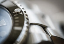 Close-up of a watch bezel, case and steel bracelet